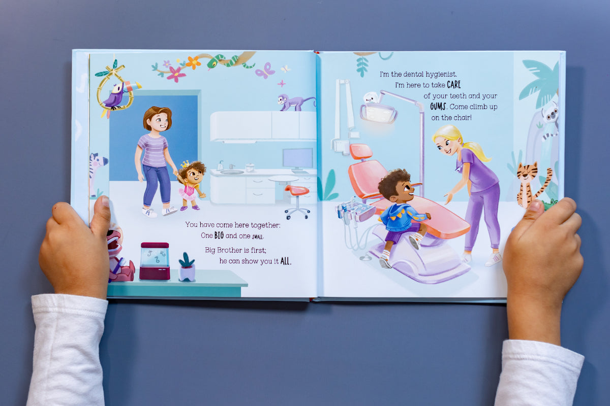 Child reading My Dental Debut open to a page showing a friendly dental hygienist helping a young boy at the dentist, promoting gentle dental care for kids. - dentist-approved stocking stuffers.